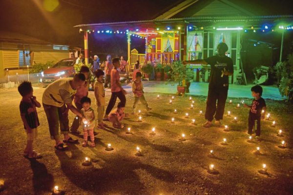KLANG 04 JULY 2016. Kanak-kanak kelihatan seronok melihat lebih 150 pelita raya yang dipasang oleh Ramli Bandi, 64, di sekitar halaman rumahnya di Jalan Sungai Udang, Klang bagi memeriahkan sambutan Hari Raya Aidilfitri pada malam tujuh likur atau 10 malam terakhir Ramadan. STR/FAIZ ANUAR